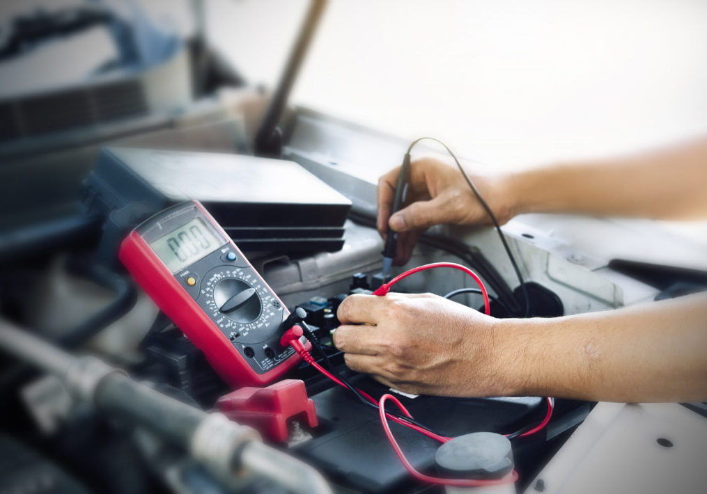 Close up of auto mechanic jumping battery car,check voltage level car battery.